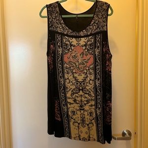 Sleeveless tunic with small black embellishments.